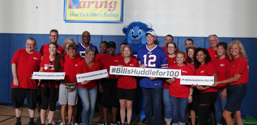 A group of Independent Health works pose for a photo with Jim Kelly, Darryl Talley, and Billy Buffalo