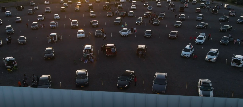 Cars sit in front of a movie screen at a Drive-In Theatre