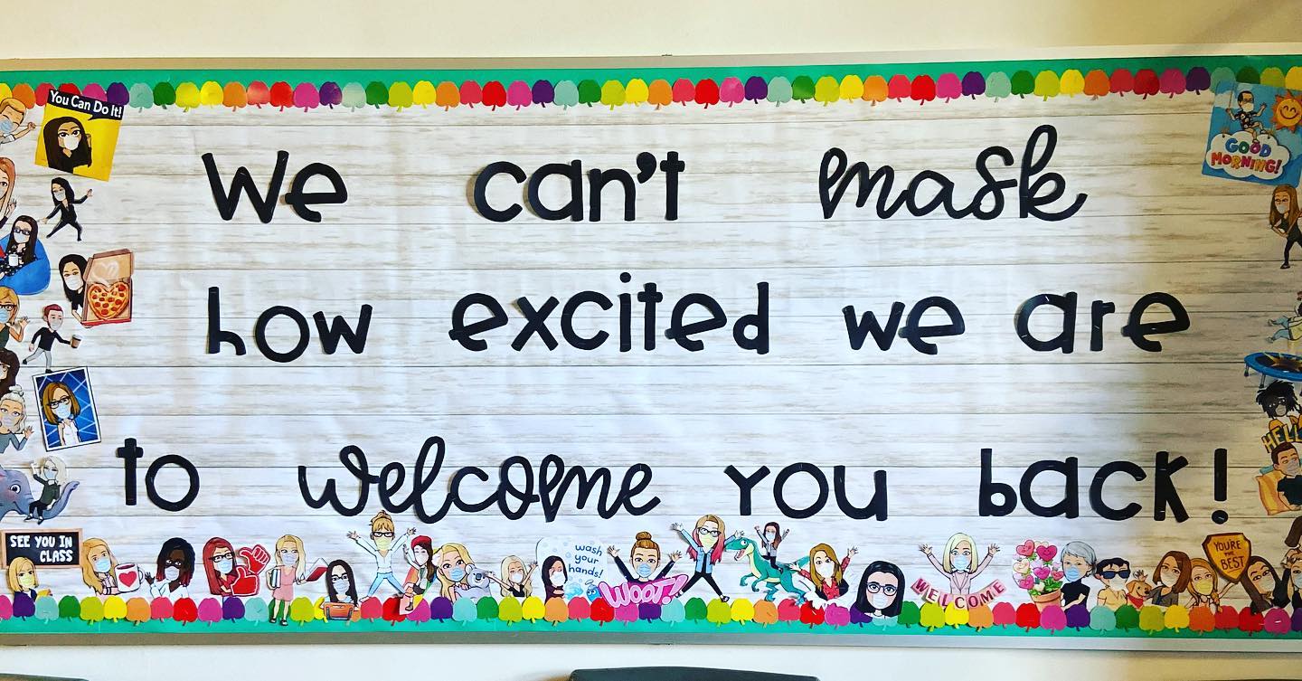 A sign in a school reads "We can't mask how excited we are to welcome you back!"