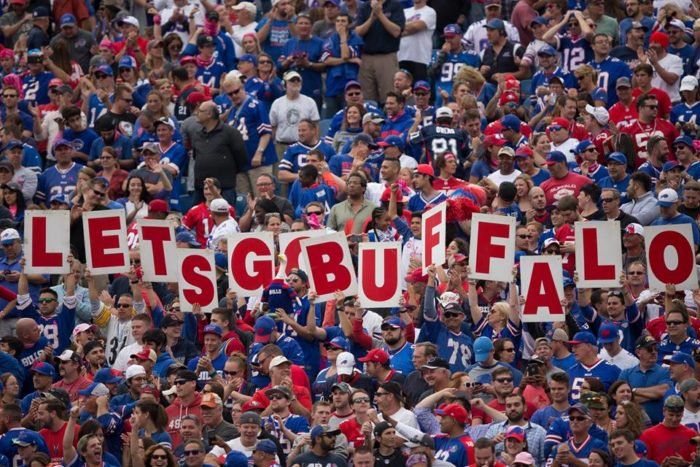 A crowd shot of Bills Stadium where fans hold up signs that spell out "Let's Go Buffalo"
